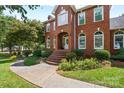 Inviting red brick home features arched windows, a brick staircase leading to the entrance, and manicured landscaping at 102 Sleaford Ct, Dallas, NC 28034