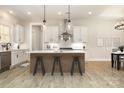 Bright kitchen features an island with bar seating, modern lighting, and stainless steel appliances at 1025 Baylor Grove Rd, Monroe, NC 28112