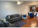 Cozy living room featuring hardwood floors, a plush sofa, and an adjacent dining area at 4327 Kobuk Ln, Charlotte, NC 28269