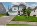 Beautiful two-story home with a well-manicured lawn, stone accents, and a covered front porch at 16725 Cozy Cove Rd, Charlotte, NC 28278