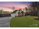 Two-story home with stone accents and a covered porch at sunset at 3001 Sparrow Springs Rd, Gastonia, NC 28052