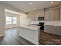 Modern kitchen with stainless steel appliances, gray cabinets, an island, and an open floor plan at 203 Alden Ct, Shelby, NC 28152