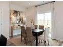 Sunlit dining room featuring modern decor, stylish furnishings, and a large window overlooking the backyard at 205 Alden Ct, Shelby, NC 28152