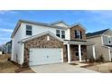 Two-story home with brick and vinyl siding, showing a concrete driveway and a two-car garage on a sunny day at 153 Shepherds Landing Dr, Mooresville, NC 28115