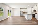 Open-concept living space featuring hardwood floors, stainless steel appliances, and a breakfast bar at 153 Shepherds Landing Dr, Mooresville, NC 28115