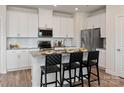 Modern kitchen featuring white cabinets, stainless steel appliances, granite counters and bar stool seating at 157 Shepherds Landing Dr, Mooresville, NC 28115