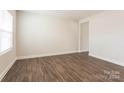 Simple bedroom with hardwood floors and large window at 179 Wembury Ln, Troutman, NC 28166