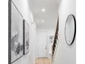 Bright hallway with hardwood floors, modern artwork, black-framed mirror, and stairs leading upstairs at 4069 Rivendell Rd # 5, Denver, NC 28037