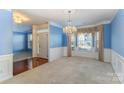 Dining room with blue walls, white trim, hardwood floors, and a bright bay window with decorative curtains at 2060 E Foxwood Ct, Indian Land, SC 29707