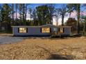 Inviting home with warm interior lighting, showcasing a cozy exterior as the day transitions to dusk at 1128 Bethesda Rd, Statesville, NC 28677
