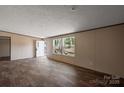 Bright, airy living room with wood-look floors, a large window, and a welcoming entrance at 1128 Bethesda Rd, Statesville, NC 28677