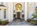 Elegant front entrance with stone steps, potted flowers, and arched doorway at 1873 Farrow Dr, Rock Hill, SC 29732