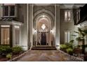 Grand home entrance featuring an arched entryway, elegant lighting, and stone pathway at 1873 Farrow Dr, Rock Hill, SC 29732