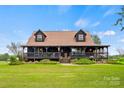 Charming log cabin home with a wraparound porch and landscaped yard at 4796 Dewitt Rd, Blackstock, SC 29014