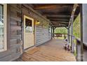 Cozy log cabin porch with a swing and a dog resting at 4796 Dewitt Rd, Blackstock, SC 29014