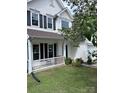 Inviting two-story home with a front porch, manicured lawn, and a two-car garage at 4741 Nijinsky Ct, Charlotte, NC 28216