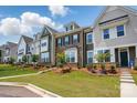 Beautiful townhome exteriors feature manicured lawns, brick, and varied architectural designs with lush landscaping at 939 Cobbled Way, Fort Mill, SC 29715