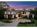 Striking front exterior featuring modern architecture, a circular driveway, and professionally landscaped grounds at 2116 Woodhaven Rd, Charlotte, NC 28211