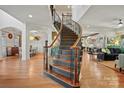 Elegant curved staircase with dark wood and wrought iron at 7812 Burning Ridge Dr, Stanley, NC 28164