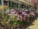 A welcoming front porch is surrounded by vibrant pink azaleas, enhancing curb appeal and creating a charming view at 1409 Trinity Church Rd, Monroe, NC 28112