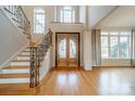 Two-story entryway with hardwood floors, elegant staircase, and double doors at 7954 Bay Pointe Dr, Denver, NC 28037