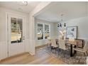 Bright dining room with a modern chandelier, wood table, and large windows at 2621 Ritz Ln, Matthews, NC 28105