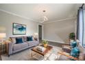 Bright living room featuring a gray sofa, wood coffee table, and stylish decor at 83 Woodsdale Se Pl, Concord, NC 28025