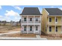 Charming two-story home boasts a black-railed porch, welcoming entrance, and light pink facade at 5840 Pittmon Ln, Kannapolis, NC 28081