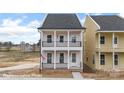 Charming two-story home with a welcoming front porch and second-story balcony, featuring black railings and white pillars at 5850 Pittmon Ln, Kannapolis, NC 28081