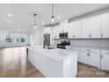 Open concept kitchen with a large island, stainless steel appliances, white cabinets, and hardwood flooring at 1609 Blanche St, Charlotte, NC 28262