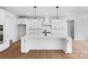 Bright white kitchen featuring a large island, stainless appliances, and modern pendant lighting at 5735 Allburn Pkwy, Concord, NC 28027