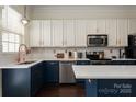 Stylish kitchen with white and blue cabinets, quartz countertops, and copper accents at 11770 Redbridge Blvd, Locust, NC 28097