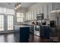 Modern kitchen boasts dark blue cabinetry, quartz countertops, and stainless steel appliances at 11770 Redbridge Blvd, Locust, NC 28097