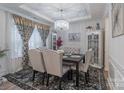 Formal dining room with a dark wood table, chandelier, and neutral decor at 13050 Regent Grove Ln, Huntersville, NC 28078