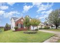 Two-story brick home with a landscaped front yard and a spacious driveway at 11434 Lamoille Ln, Charlotte, NC 28278