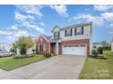 Two-story brick home with a white garage door and well-manicured lawn at 11434 Lamoille Ln, Charlotte, NC 28278