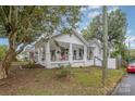 White house with porch, large tree, and partial street view at 317 Kerr Nw St, Concord, NC 28025