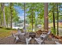 Cozy fire pit area surrounded by chairs, perfect for enjoying evenings by the water with serene lake and dock views at 470 Lakeview Shores Loop, Mooresville, NC 28117