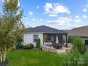 Home's back exterior showcasing a screened porch and patio area with fire pit at 494 Bowline Dr, Denver, NC 28037