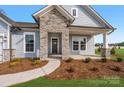 Inviting home featuring a stone porch and siding with manicured landscaping and a paved walkway at 3228 Gavin Ln, Harrisburg, NC 28075
