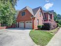 Attached two-car garage with a concrete driveway and manicured landscaping at 907 Weymouth Dr, Gastonia, NC 28056