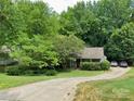 Charming home featuring a well-manicured lawn, mature trees, and a long driveway leading to a cozy residence at 732 Shawnee Dr, Charlotte, NC 28209