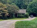 Inviting home with lush greenery, mature trees, and a curved driveway leading to the residence at 732 Shawnee Dr, Charlotte, NC 28209