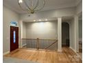 Inviting home entryway with hardwood floors, elegant columns, and a striking front door at 10604 Russet Pl, Charlotte, NC 28227