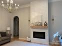 Cozy living room featuring a shiplap fireplace, hardwood floors, and stylish decor at 10604 Russet Pl, Charlotte, NC 28227
