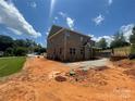 Two-story brick home with a covered deck offers an ideal space for outdoor relaxation and entertaining with nature views at 8605 Carly Ln, Mint Hill, NC 28227