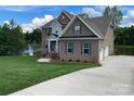 Charming brick home featuring a three-car garage and scenic lake views at 9411 Stonebridge Way # 49, Mint Hill, NC 28227