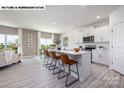 Open-concept kitchen with white cabinets, an island with seating, and modern appliances at 107 Rustling Waters Dr, Mooresville, NC 28117