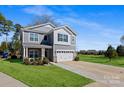 Two-story gray house with a two-car garage and playground in the background at 5703 Eleanor Rigby Rd, Charlotte, NC 28278