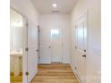 Bright hallway with wood floors features white doors and a glimpse of a half bathroom at 4057 Lawnview Dr, Charlotte, NC 28269